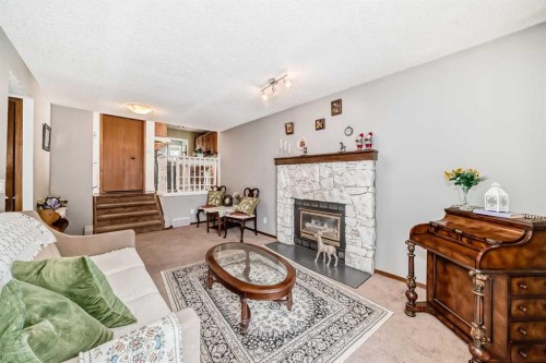 216 Hawkwood Boulevard Nw, Calgary, AB - Indoor Photo Showing Living Room With Fireplace