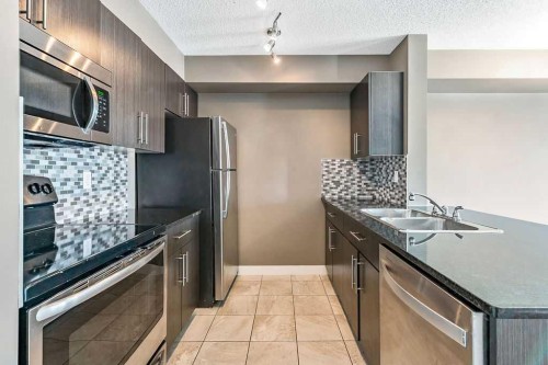 9410-403 Mackenzie Way Sw, Airdrie, AB - Indoor Photo Showing Kitchen With Double Sink With Upgraded Kitchen
