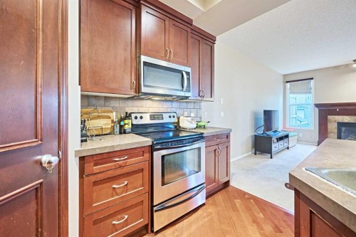 789 Panatella Boulevard Nw, Calgary, AB - Indoor Photo Showing Kitchen With Fireplace