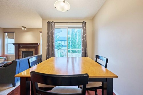 789 Panatella Boulevard Nw, Calgary, AB - Indoor Photo Showing Dining Room With Fireplace