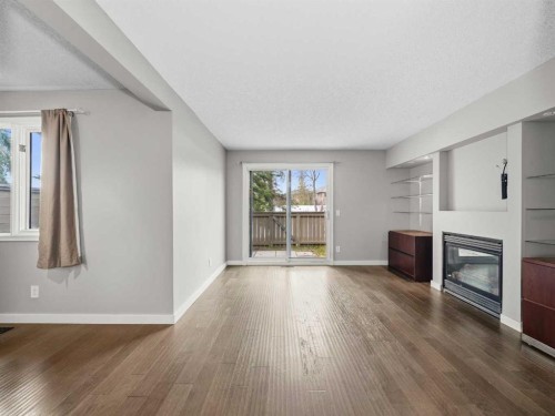 202-829 Coach Bluff Crescent Sw, Calgary, AB - Indoor Photo Showing Living Room With Fireplace
