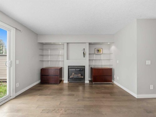202-829 Coach Bluff Crescent Sw, Calgary, AB - Indoor Photo Showing Living Room With Fireplace