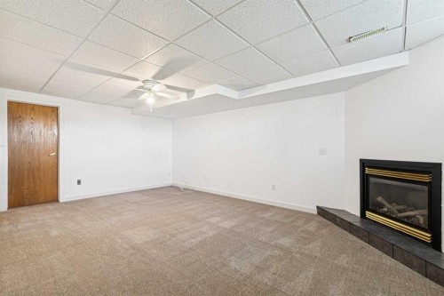 34-105 Elm Place, Okotoks, AB - Indoor Photo Showing Other Room With Fireplace