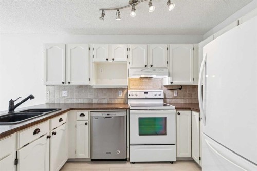 34-105 Elm Place, Okotoks, AB - Indoor Photo Showing Kitchen With Double Sink