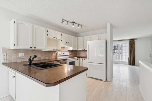 34-105 Elm Place, Okotoks, AB - Indoor Photo Showing Kitchen With Double Sink