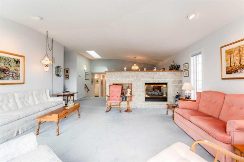 8 Prominence Path Sw, Calgary, AB - Indoor Photo Showing Living Room With Fireplace
