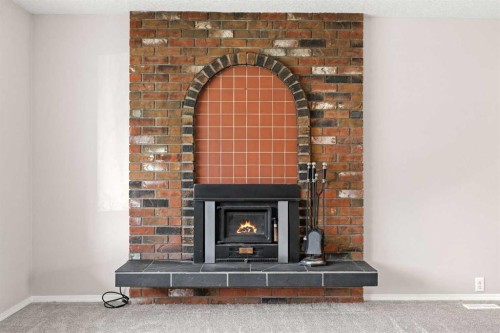 7720 Hunterquay Road Nw, Calgary, AB - Indoor Photo Showing Living Room With Fireplace