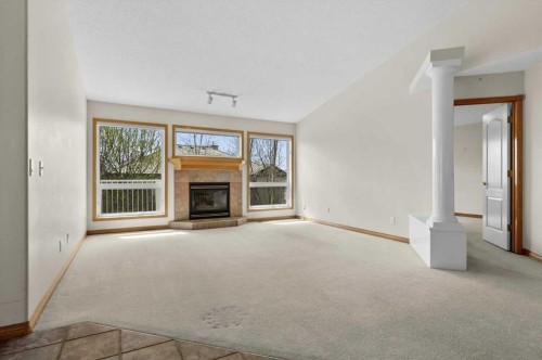 122 Rocky Ridge Villas Nw, Calgary, AB - Indoor Photo Showing Living Room With Fireplace