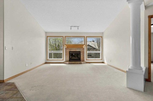 122 Rocky Ridge Villas Nw, Calgary, AB - Indoor Photo Showing Other Room With Fireplace