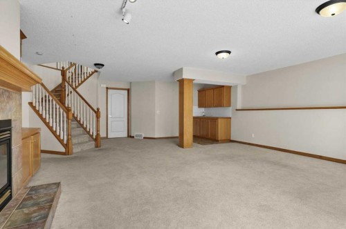 122 Rocky Ridge Villas Nw, Calgary, AB - Indoor Photo Showing Other Room With Fireplace