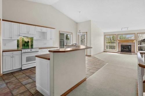 122 Rocky Ridge Villas Nw, Calgary, AB - Indoor Photo Showing Kitchen With Fireplace