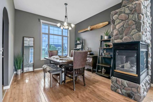 1105 Turner Gate Sw, Diamond Valley, AB - Indoor Photo Showing Dining Room With Fireplace