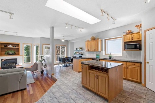 545 Rocky Ridge Bay Nw, Calgary, AB - Indoor Photo Showing Kitchen With Fireplace