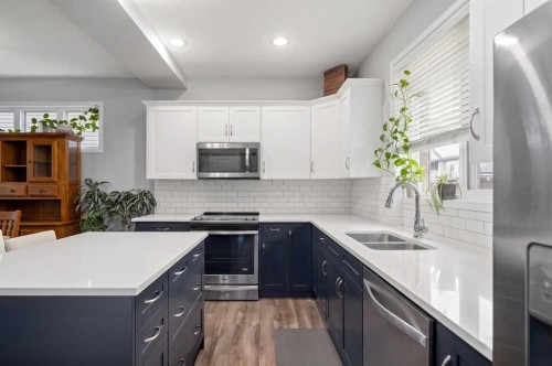 39 Heritage Boulevard, Cochrane, AB - Indoor Photo Showing Kitchen With Stainless Steel Kitchen With Double Sink With Upgraded Kitchen