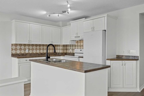 289 Hidden Spring Green Nw, Calgary, AB - Indoor Photo Showing Kitchen With Double Sink