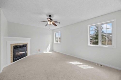289 Hidden Spring Green Nw, Calgary, AB - Indoor Photo Showing Other Room With Fireplace