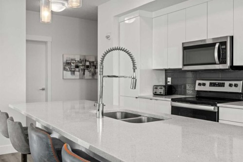 305-19661 40 Street Se, Calgary, AB - Indoor Photo Showing Kitchen With Stainless Steel Kitchen With Double Sink With Upgraded Kitchen