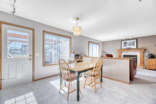 7 Springs Crescent Se, Airdrie, AB - Indoor Photo Showing Dining Room With Fireplace