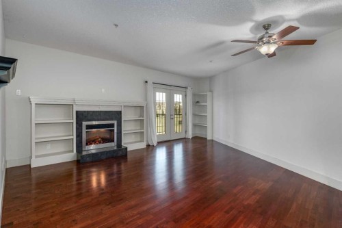 213-77 George Fox Trail West, Cochrane, AB - Indoor Photo Showing Other Room With Fireplace