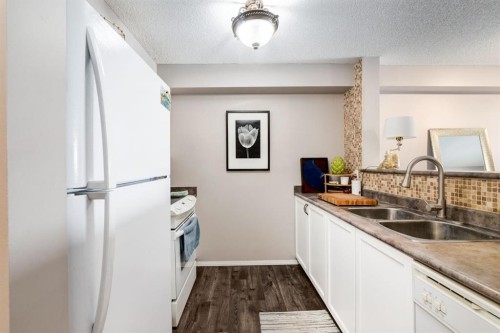 1414-12 Cimarron Common, Okotoks, AB - Indoor Photo Showing Kitchen With Double Sink