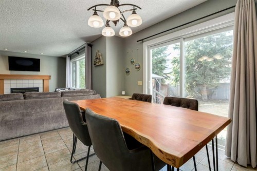 159 Macewan Drive Nw, Calgary, AB - Indoor Photo Showing Dining Room With Fireplace