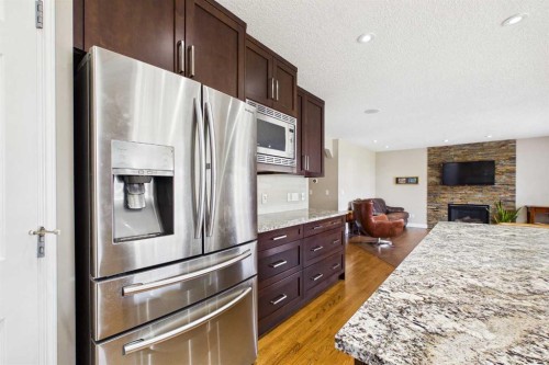 149 Tuscany Ravine Bay Nw, Calgary, AB - Indoor Photo Showing Kitchen With Fireplace