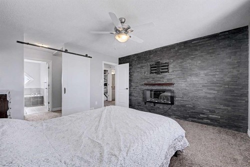 644 Luxstone Landing Sw, Airdrie, AB - Indoor Photo Showing Bedroom With Fireplace
