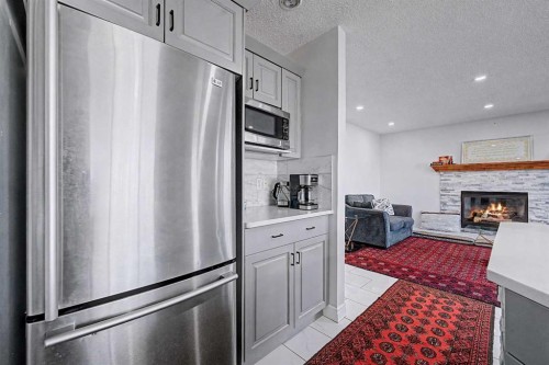 644 Luxstone Landing Sw, Airdrie, AB - Indoor Photo Showing Kitchen With Fireplace With Stainless Steel Kitchen