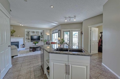 111 West Springs Way Sw, Calgary, AB - Indoor Photo Showing Kitchen With Fireplace With Double Sink