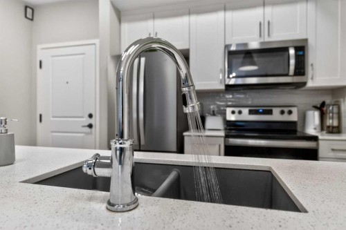218-140 Mahogany Street Se, Calgary, AB - Indoor Photo Showing Kitchen With Stainless Steel Kitchen With Double Sink With Upgraded Kitchen