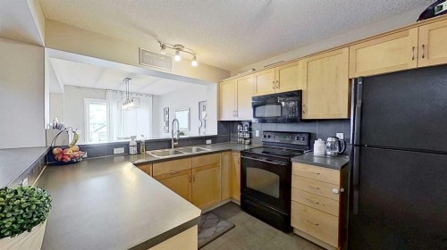 17 Sunset Heights, Cochrane, AB - Indoor Photo Showing Kitchen With Double Sink