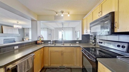 17 Sunset Heights, Cochrane, AB - Indoor Photo Showing Kitchen With Double Sink