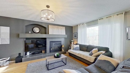 17 Sunset Heights, Cochrane, AB - Indoor Photo Showing Living Room With Fireplace