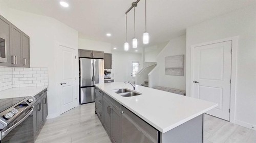 55 Belgian Crescent, Cochrane, AB - Indoor Photo Showing Kitchen With Double Sink With Upgraded Kitchen