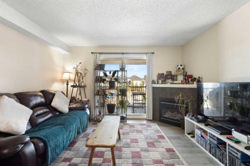 2320-2371 Eversyde Avenue Sw, Calgary, AB - Indoor Photo Showing Living Room With Fireplace