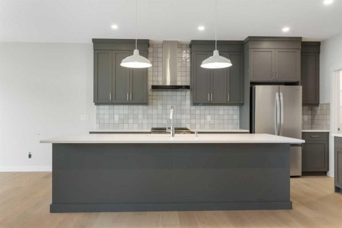 125 Southborough Common, Cochrane, AB - Indoor Photo Showing Kitchen With Stainless Steel Kitchen With Upgraded Kitchen
