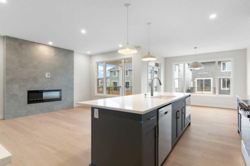 125 Southborough Common, Cochrane, AB - Indoor Photo Showing Kitchen With Fireplace With Upgraded Kitchen