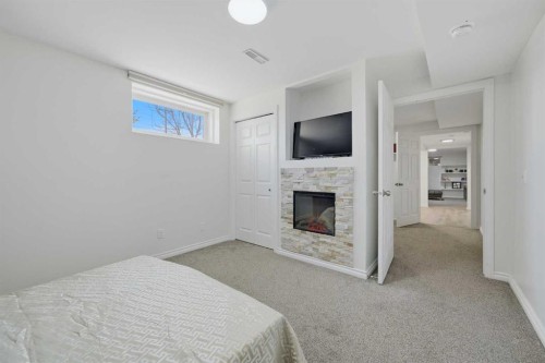 55 Ross Place, Crossfield, AB - Indoor Photo Showing Bedroom With Fireplace