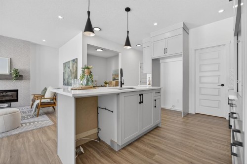 1090 Bayview Crescent, Airdrie, AB - Indoor Photo Showing Kitchen With Fireplace