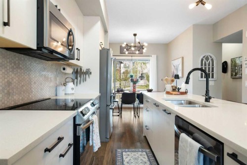 1306 Jumping Pound Common, Cochrane, AB - Indoor Photo Showing Kitchen With Double Sink With Upgraded Kitchen