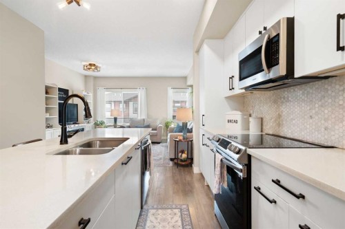 1306 Jumping Pound Common, Cochrane, AB - Indoor Photo Showing Kitchen With Double Sink With Upgraded Kitchen