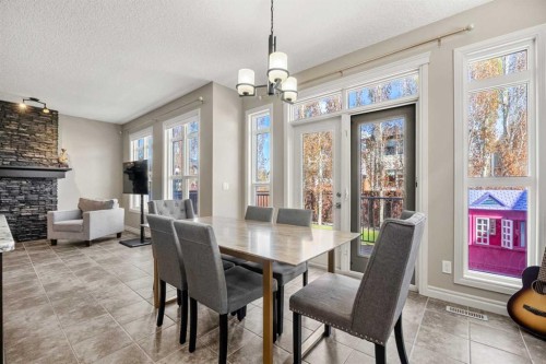 495 Cranford Drive Se, Calgary, AB - Indoor Photo Showing Dining Room With Fireplace