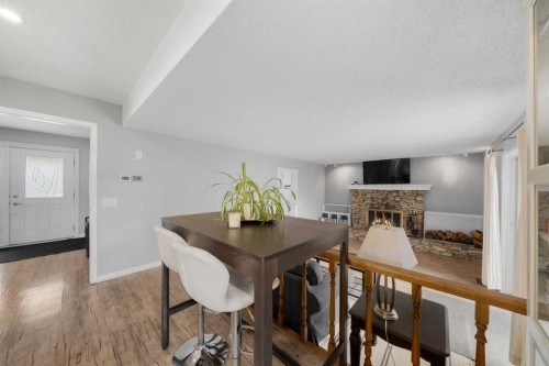 38 Suntree Lane, Okotoks, AB - Indoor Photo Showing Dining Room With Fireplace