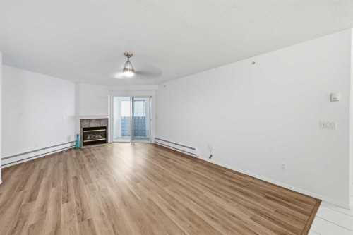 439-165 Manora Place Ne, Calgary, AB - Indoor Photo Showing Other Room With Fireplace