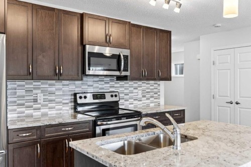 99 Buckskin Way, Cochrane, AB - Indoor Photo Showing Kitchen With Double Sink With Upgraded Kitchen