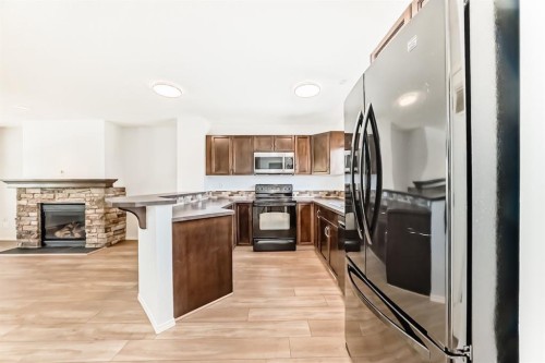 137 Eversyde Boulevard Sw, Calgary, AB - Indoor Photo Showing Kitchen With Fireplace