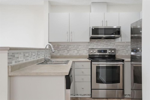 204-760 Railway Gate Sw, Airdrie, AB - Indoor Photo Showing Kitchen With Stainless Steel Kitchen With Double Sink With Upgraded Kitchen