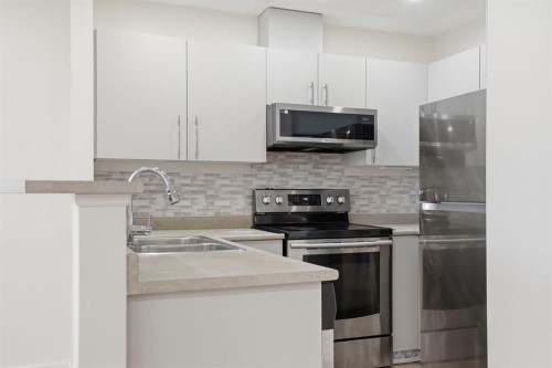 204-760 Railway Gate Sw, Airdrie, AB - Indoor Photo Showing Kitchen With Stainless Steel Kitchen With Double Sink With Upgraded Kitchen