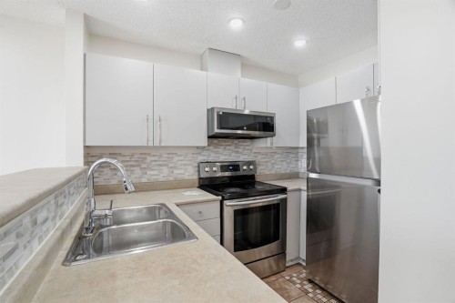 204-760 Railway Gate Sw, Airdrie, AB - Indoor Photo Showing Kitchen With Stainless Steel Kitchen With Double Sink With Upgraded Kitchen