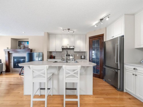 28 Cranberry Lane Se, Calgary, AB - Indoor Photo Showing Kitchen With Fireplace With Stainless Steel Kitchen With Double Sink With Upgraded Kitchen